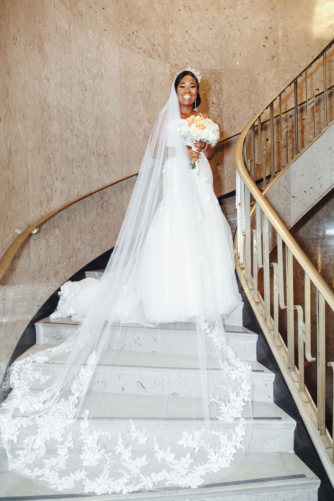 Bride on a curved staircase with a cathedral veil