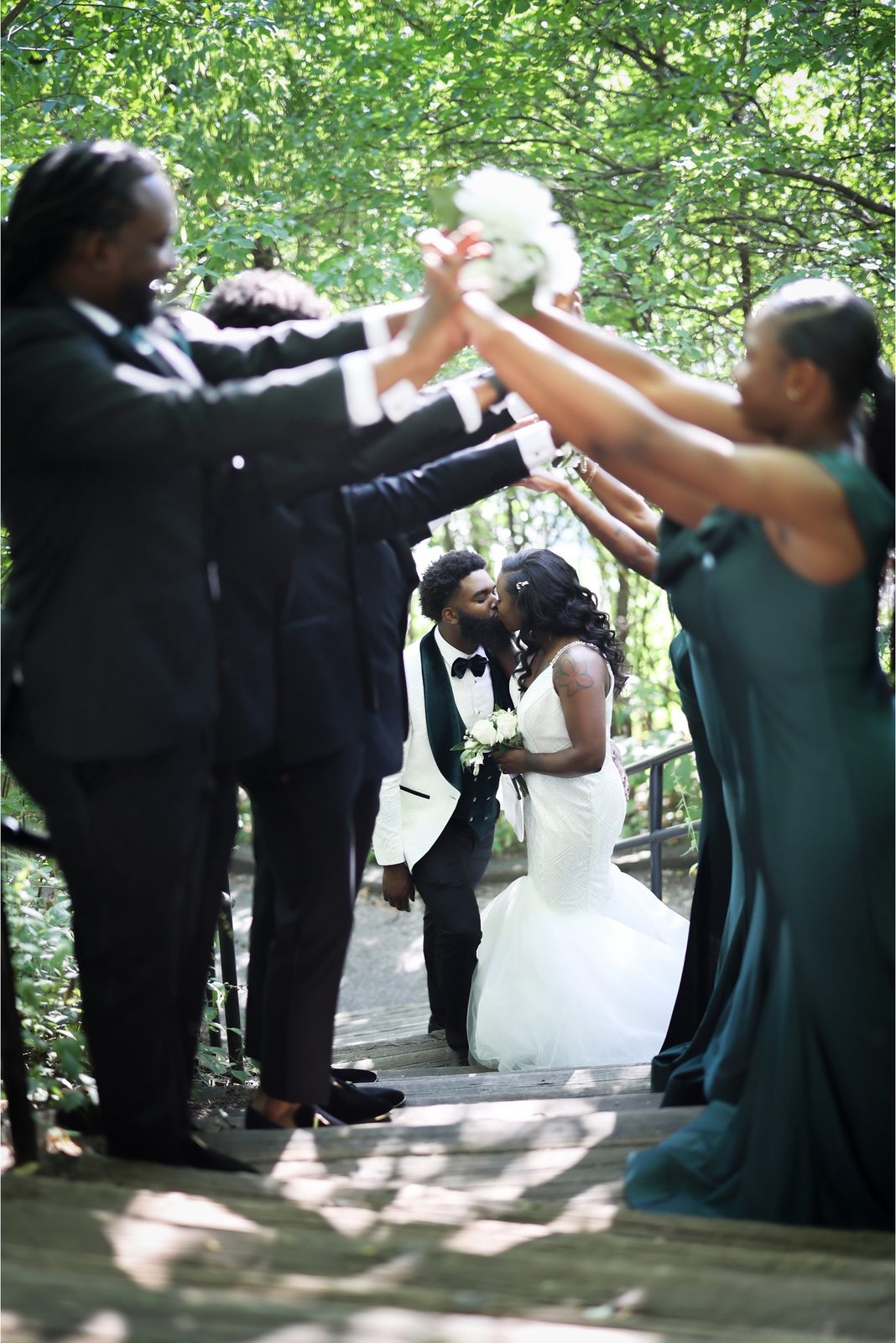 Couple kissing under a tunnel of raised arms