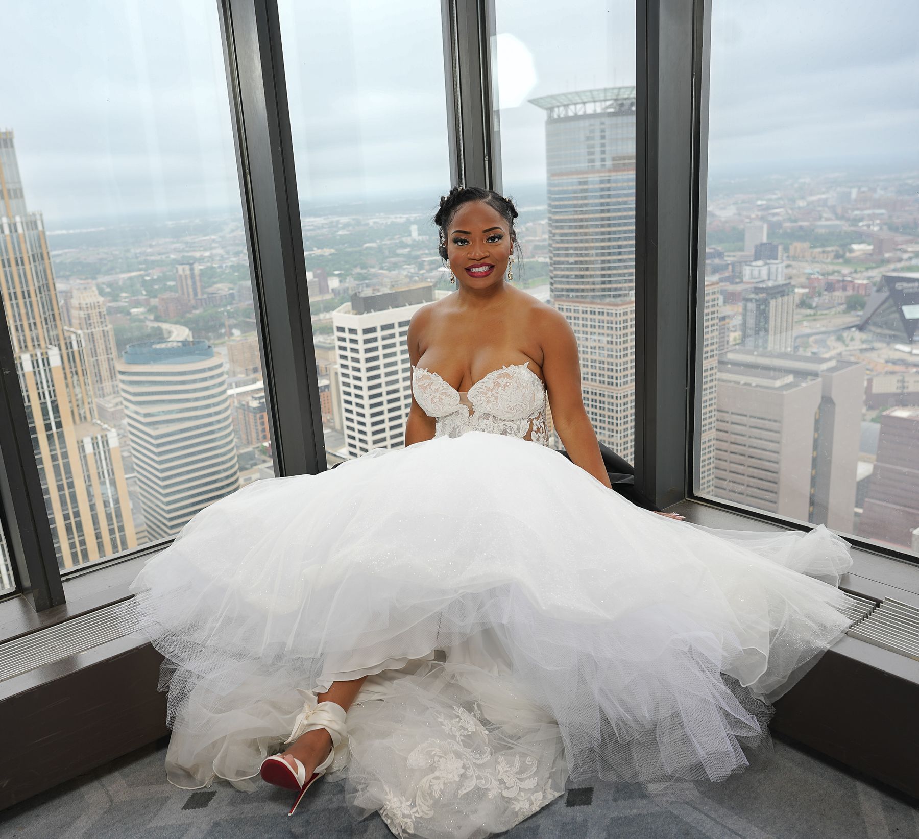 Bride in a tulle gown at a skyline window